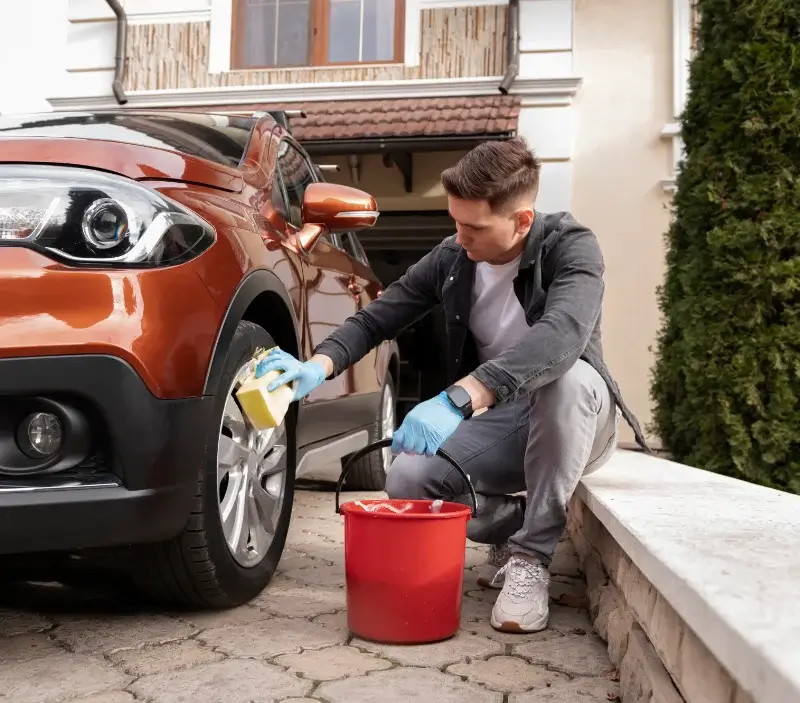 Lavage auto à domicile Auvers-le-Hamon : professionnel intervenant sur un véhicule